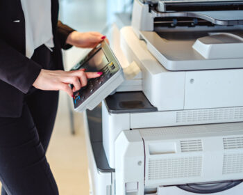 Woman at a copier machine making copies.