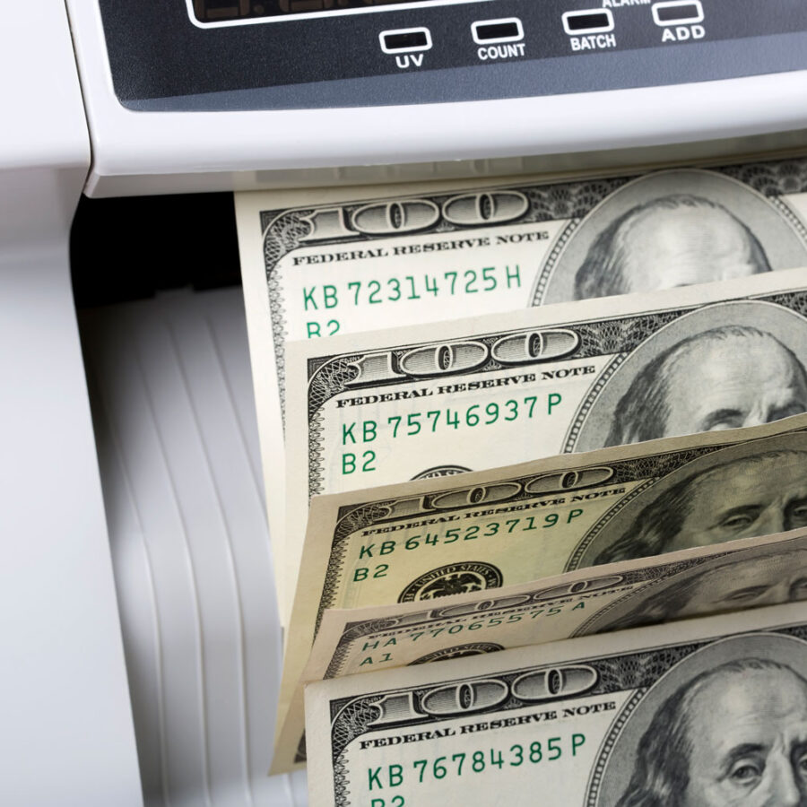 One hundred dollar bills in a money counting machine.